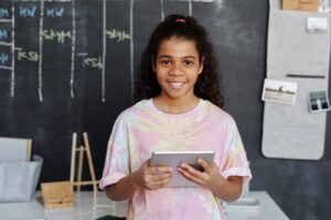 young girl holding tablet facing camera