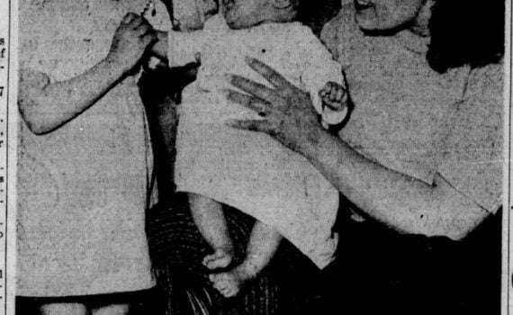 newspaper article with image of young mother with baby and young daughter, text and headline