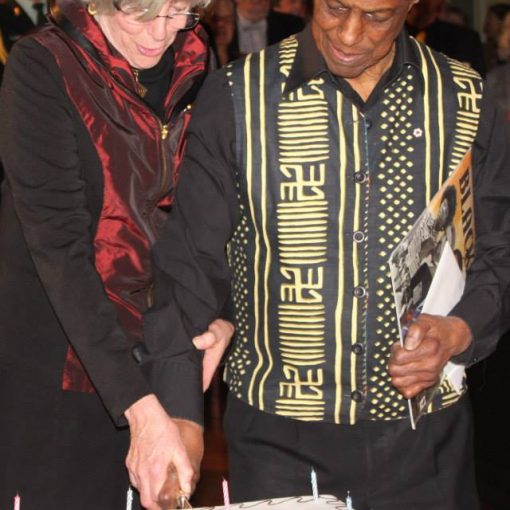 man and woman standing together cutting birthday cake