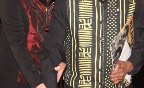man and woman standing together cutting birthday cake