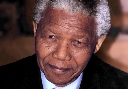 head shot senior black man, suit and patterned tie, looking directly into the camera