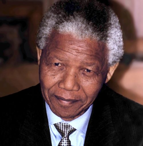 head shot senior black man, suit and patterned tie, looking directly into the camera