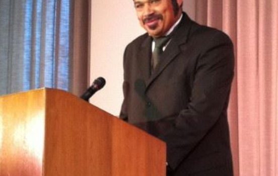 justin carter, suit & beard standing at podium portraying Mifflin Gibbs