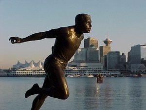bronze statue side facing man running with arms outstretched