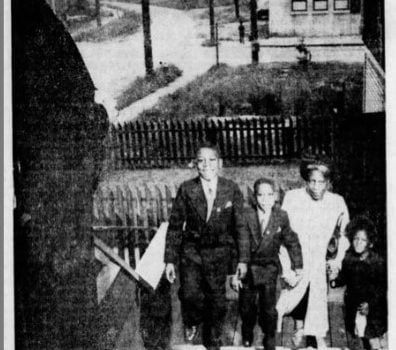 b&w newspaper photo-family walking up front steps of churchtering church