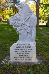white marble tablet on concrete base with carved winged angel on top