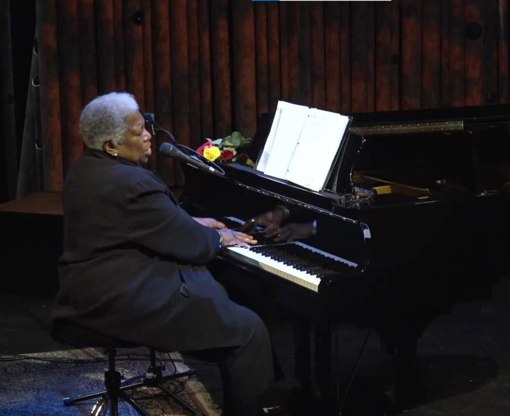 Louise Rose playing piano on stage