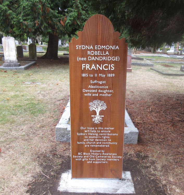 medium-colored wooden-stained grave marker with white lettering