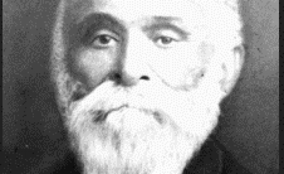 Black & white portrait of older male in suit with full white beard