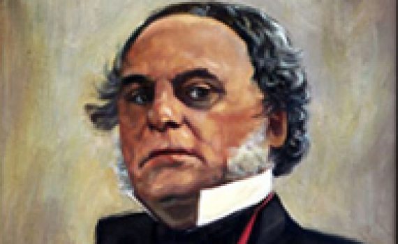 official professional portrait of older manwearing tuxedo, winged collar, medal on lapel