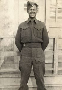 b&w young man standing hands behind back in military uniform