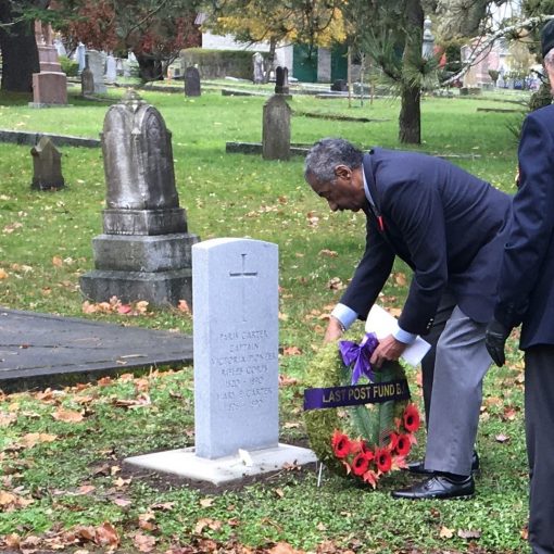 man places wreath at gravemarker