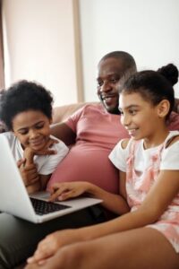 family siting on couch looking at computer