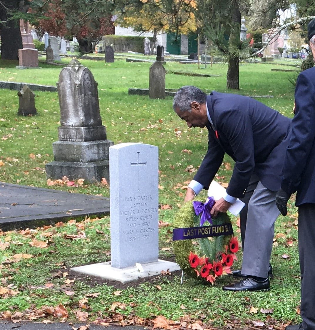 man laying wreath at gravesite