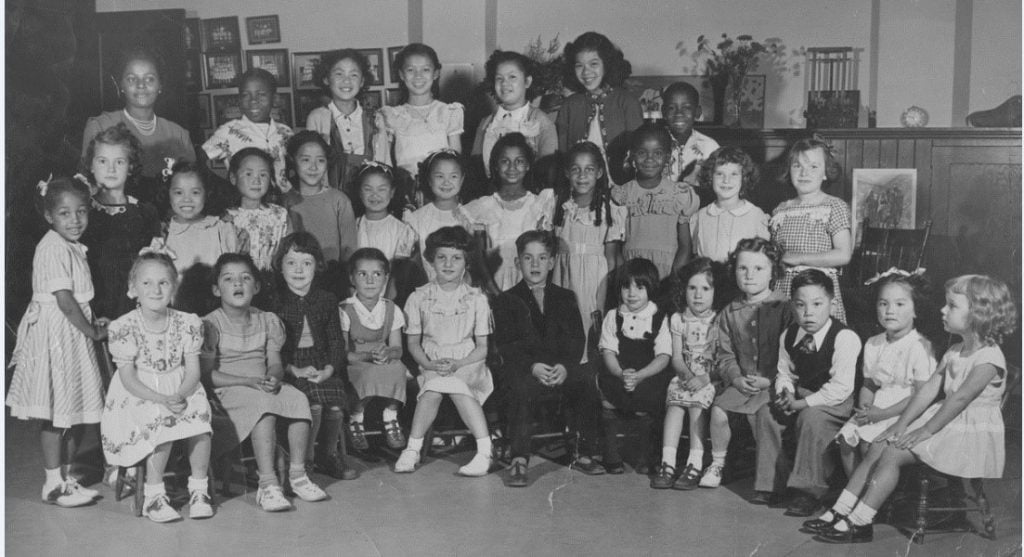 classroom photo of 30 multi-racial children seated and standing