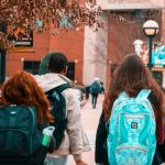 group of high school students with backpacks entering a school