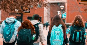 group of high school students with backpacks entering a school