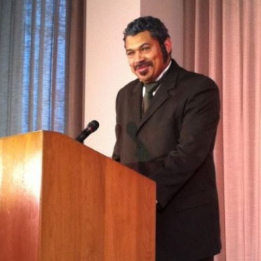 justin carter, suit & beard standing at podium portraying Mifflin Gibbs