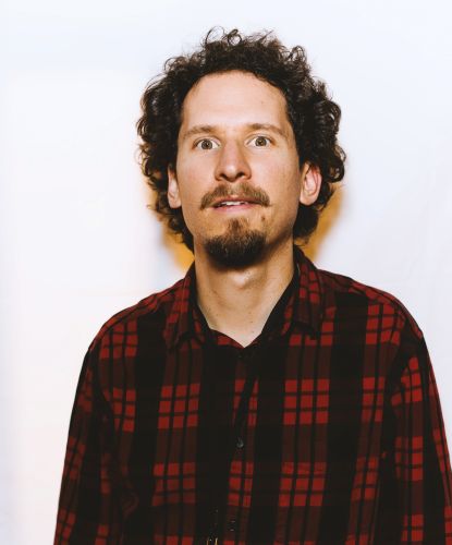 headshot-man with mustache, goatee, shorter curly hair, plaid casual shirt